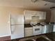 Kitchen view features white appliances, cabinets, and an adjacent laundry area at 1315 Old Coach Sw Rd, Marietta, GA 30008