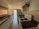 Kitchen view features white appliances, cabinets, a double sink, and an open layout to the rest of the home at 1315 Old Coach Sw Rd, Marietta, GA 30008
