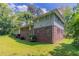 Backyard view of the home showcasing its siding, grassy area, and mature trees at 1956 Joseph Ct, Decatur, GA 30032