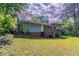 Backyard featuring a large grassy area, trees, and the rear view of the home at 1956 Joseph Ct, Decatur, GA 30032