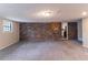 Finished basement features exposed brick wall, drop ceiling, and neutral colored carpet at 1956 Joseph Ct, Decatur, GA 30032