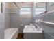 Bathroom with a tub, toilet, and sink, all with grey tiling accents at 1956 Joseph Ct, Decatur, GA 30032