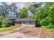 Exterior view of a house with light siding, brick accents, a driveway, and mature trees at 1956 Joseph Ct, Decatur, GA 30032