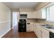 Functional kitchen features white cabinets, black appliances, laminate countertops, and hardwood flooring at 1956 Joseph Ct, Decatur, GA 30032