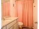 Full bath with granite vanity, toilet and shower with peach-colored curtain at 284 Bryson Lake Cir, Douglasville, GA 30134