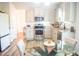 Bright kitchen featuring white cabinets, stainless steel appliances, granite countertops, and a glass dining table at 284 Bryson Lake Cir, Douglasville, GA 30134