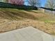 A large backyard with sparse grass, a concrete patio, and a wooden fence at 4192 Medlock River Ct, Snellville, GA 30039