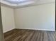 A bedroom featuring modern wood-look flooring and a tray ceiling with decorative molding at 4192 Medlock River Ct, Snellville, GA 30039