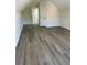 Large bonus room with wood-look floors, vaulted ceilings, and multiple storage closets at 4192 Medlock River Ct, Snellville, GA 30039