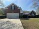 Charming two-story home with a brick facade, attached garage, and beautifully landscaped front yard at 4192 Medlock River Ct, Snellville, GA 30039