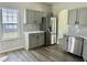 Eat-in kitchen features stainless steel appliances, sleek gray cabinetry, new hardwood floors and marble counters at 4192 Medlock River Ct, Snellville, GA 30039