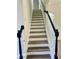 A staircase with white risers, wood-look treads, and an elegant black handrail at 4192 Medlock River Ct, Snellville, GA 30039