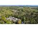 Bird's eye view of a neighborhood with tree-lined streets near wooded areas and a pond at 1720 Barclay Close Nw, Atlanta, GA 30318