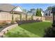 Landscaped backyard featuring tiered stone walls, lush grass, privacy fence, and thoughtfully placed trees and greenery at 1720 Barclay Close Nw, Atlanta, GA 30318