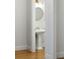 Bathroom featuring a pedestal sink with gold fixtures, a round mirror, and neutral walls and floors at 1720 Barclay Close Nw, Atlanta, GA 30318