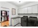 Modern laundry room with washer, dryer, cabinets, and closet access at 1720 Barclay Close Nw, Atlanta, GA 30318