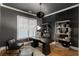 Home office featuring a dark statement wall, desk, bookshelves, and bright window for a comfortable work environment at 1720 Barclay Close Nw, Atlanta, GA 30318