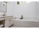 A bright bathroom featuring a large soaking tub with a stylish faucet and a vanity with modern accents at 3897 Beacon St, Marietta, GA 30062