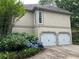 Attached two-car garage with white doors surrounded by lush hydrangeas and green foliage at 3897 Beacon St, Marietta, GA 30062