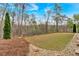 The level grassy area leads to a treed landscape behind the house at 359 Woodridge Pass, Canton, GA 30114