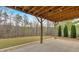 Concrete patio under a wood deck with a view of the treed backyard at 359 Woodridge Pass, Canton, GA 30114