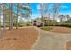 A sidewalk leads to the community clubhouse, surrounded by pine straw and trees at 359 Woodridge Pass, Canton, GA 30114