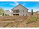 Rear view of the home featuring a deck, a patio, and a sloped, wooded lot at 359 Woodridge Pass, Canton, GA 30114