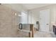 Bathroom featuring frameless glass shower with bench and neutral tiling at 359 Woodridge Pass, Canton, GA 30114