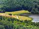 Aerial view of a serene lake surrounded by lush greenery and winding paths at 3965 Hamilton View Way, Dacula, GA 30019