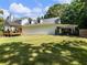 Home's sprawling backyard featuring a patio, house, car port, manicured lawn and surrounding mature trees at 3965 Hamilton View Way, Dacula, GA 30019