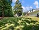 Spacious backyard with a well-maintained lawn, mature trees, and a charming patio with a deck at 3965 Hamilton View Way, Dacula, GA 30019
