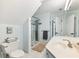 Bright bathroom featuring a toilet, white tiled floor, sink, a shower with patterned tile, and soft blue colored walls at 3965 Hamilton View Way, Dacula, GA 30019