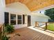 Charming backyard porch with wood ceiling and flooring, white siding, black shutters, and lush greenery at 3965 Hamilton View Way, Dacula, GA 30019