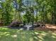Backyard fire pit area with stone pavers, seating, and surrounding landscaping, ideal for outdoor entertaining at 3965 Hamilton View Way, Dacula, GA 30019