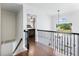 Hallway with dark wood floors, black wrought iron railing and an arched window at 3965 Hamilton View Way, Dacula, GA 30019