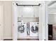 Laundry room with a front-loading washer and dryer and white cabinets above at 3965 Hamilton View Way, Dacula, GA 30019