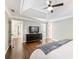 Main bedroom featuring a large dresser, tray ceiling, ceiling fan, and hardwood floors at 3965 Hamilton View Way, Dacula, GA 30019