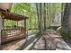 A spacious backyard with a covered porch surrounded by trees at 5269 Blue Grass Ln, Sugar Hill, GA 30518