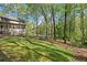 Lush backyard with mature trees surrounding the house, providing shade and privacy at 5269 Blue Grass Ln, Sugar Hill, GA 30518