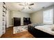 A bright bedroom with wood floors features a ceiling fan and large window at 7660 Brentwood Ct, Cumming, GA 30040