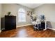 Neutral bedroom featuring hardwood floors, a black dresser, desk, and arched window with blinds at 7660 Brentwood Ct, Cumming, GA 30040