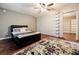 Bedroom featuring hardwood floors, ceiling fan, and an adjoining sitting or dressing area at 7660 Brentwood Ct, Cumming, GA 30040