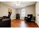 Bright bedroom with hardwood floors, a ceiling fan, and a sitting area by the window at 7660 Brentwood Ct, Cumming, GA 30040