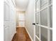 Hallway features a closet, wood floors, and a glass paneled door at 7660 Brentwood Ct, Cumming, GA 30040