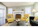 Cozy living room with a fireplace, vaulted ceiling, and large windows providing natural light at 7660 Brentwood Ct, Cumming, GA 30040