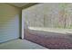 View of a flat back yard from the covered porch area with peaceful wooded backdrop at 234 Madison Ave, Acworth, GA 30102