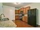 Bright kitchen features stainless steel refrigerator, granite counters, wood cabinets, and hardwood floors at 234 Madison Ave, Acworth, GA 30102