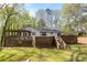 Exterior view of home showcasing an expansive wooden deck, stairs to backyard, and lush greenery at 3378 Peachtree Chase, Duluth, GA 30096