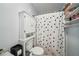 Cozy bathroom featuring a white toilet, polka dot shower curtain, and storage cabinet at 3800 Lake Pass Ln, Suwanee, GA 30024