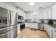 Modern kitchen with white cabinets, stainless steel appliances, granite countertops, and hardwood floors at 3800 Lake Pass Ln, Suwanee, GA 30024